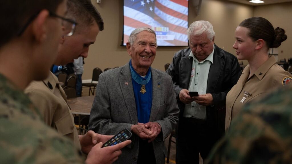 Medal of honor recipient laughs with young service members.